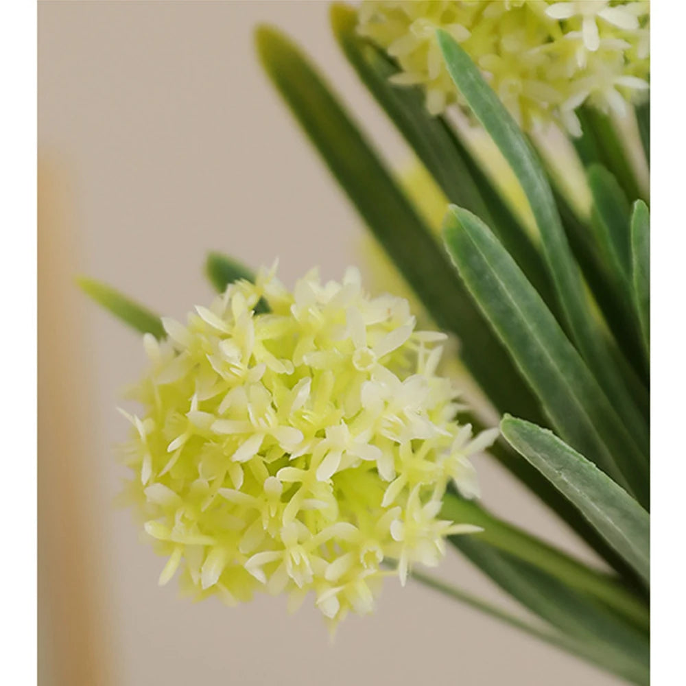 Artificial dandelion bouquet in soft yellow with lush green leaves for home decor