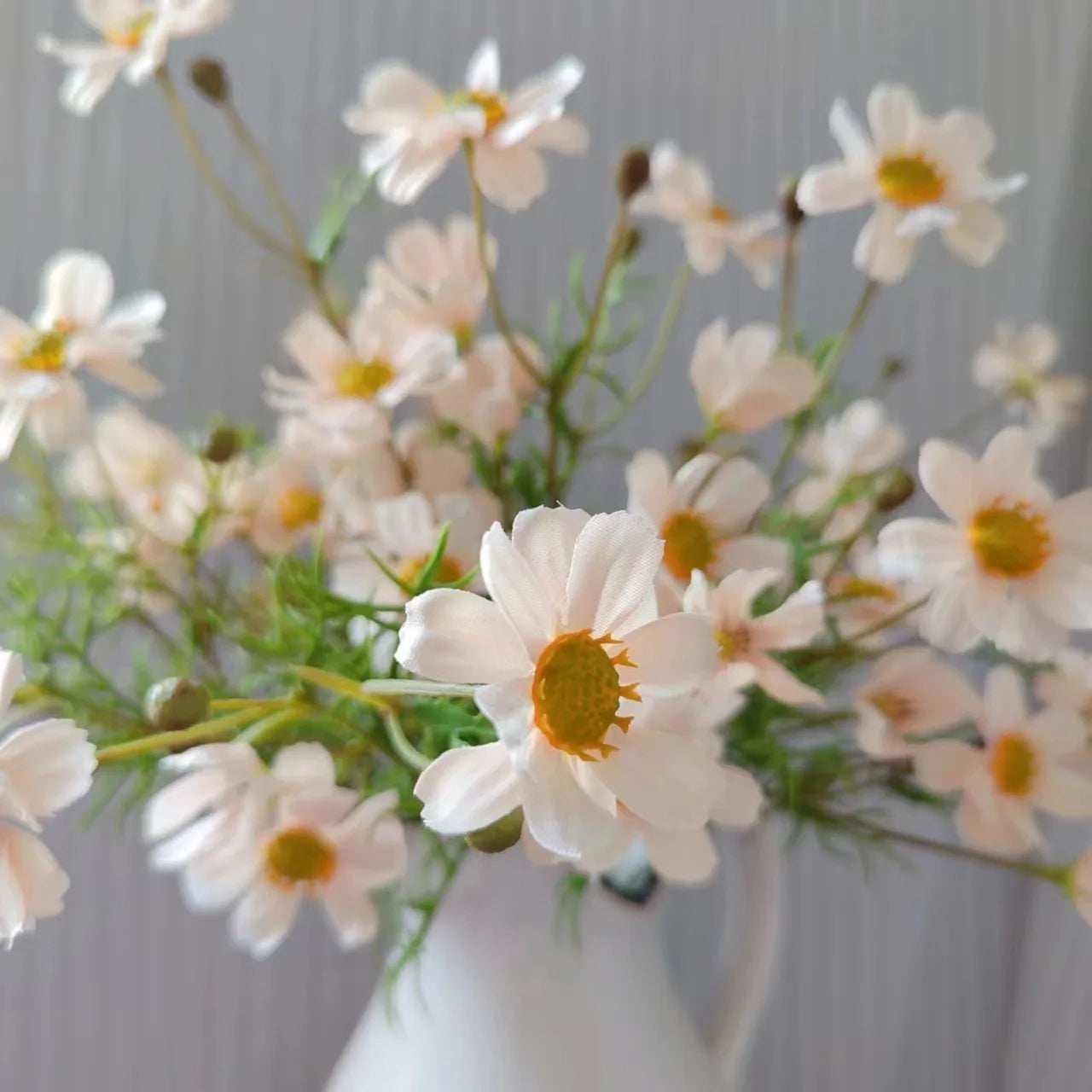 Artificial white daisy flower bouquet in a white vase for home decoration