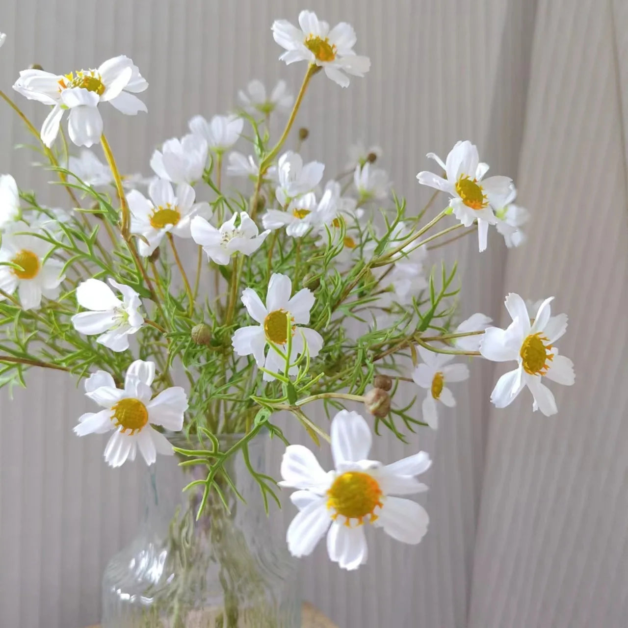 Artificial white daisies bouquet in a glass vase for home decor