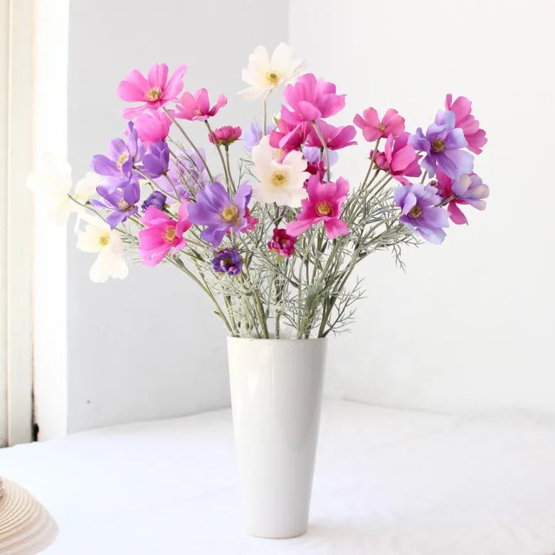 Colorful bouquet of pink and purple flowers in a white vase for home decor