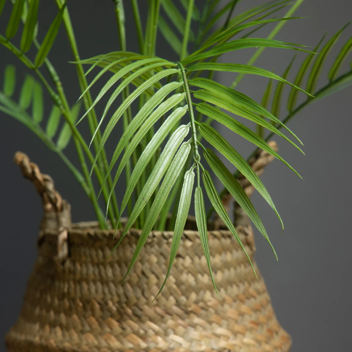 Artificial palm leaf in a woven basket by Mağazam, perfect for home decor and indoor greenery