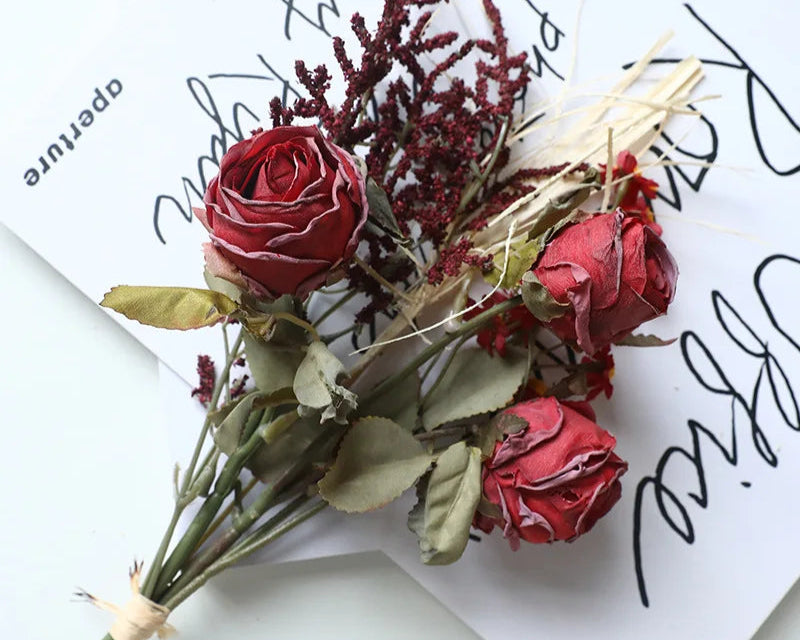 Artificial rose bouquet autumn with red roses and decorative foliage on a stylish background