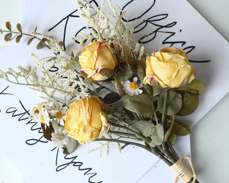 Artificial rose bouquet autumn with yellow roses and delicate white daisies on a decorative backdrop