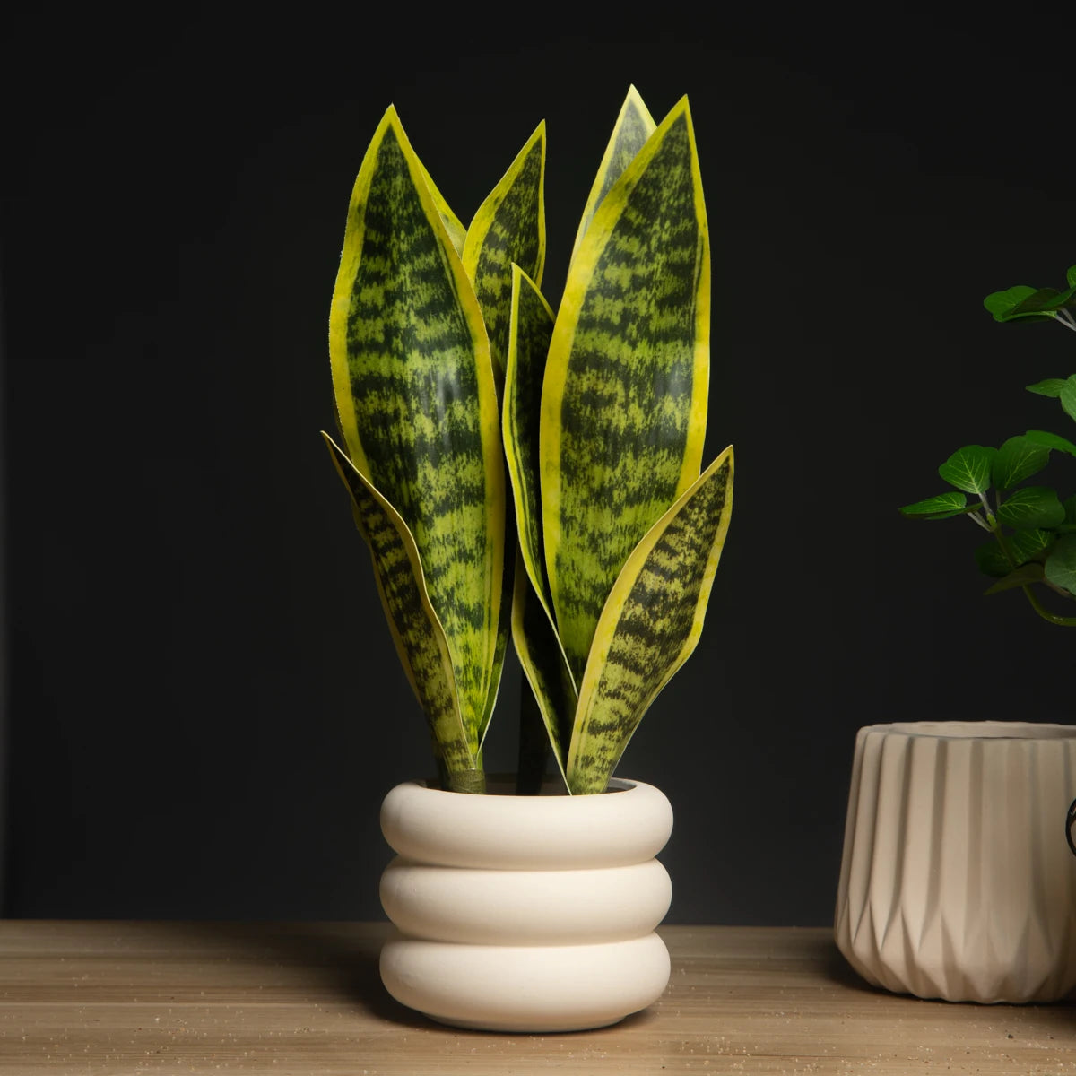 Artificial snake plant decor in a modern white pot with vibrant green leaves for home styling