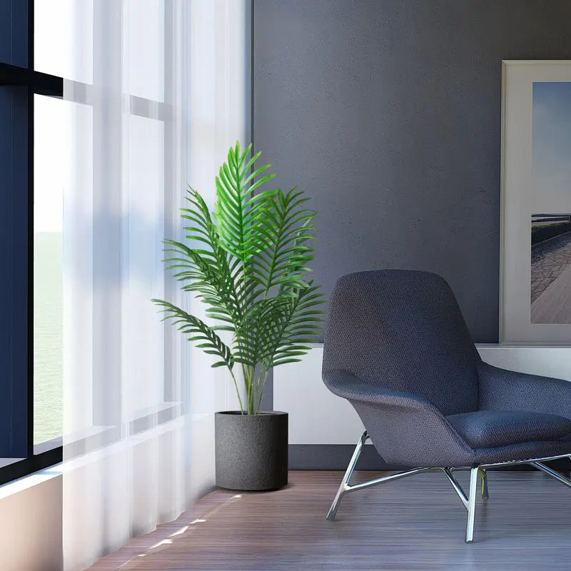 Modern living room with a gray chair, potted plant, and large windows allowing natural light