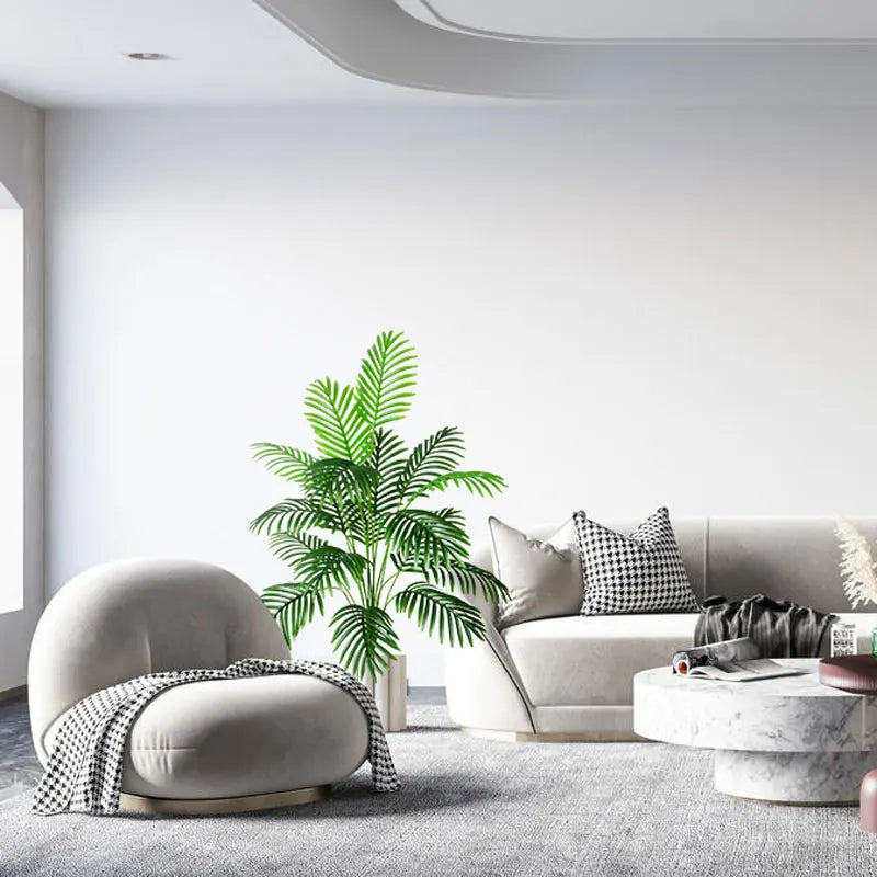 Modern living room with a cozy round sofa and a decorative potted palm plant in a bright, airy space