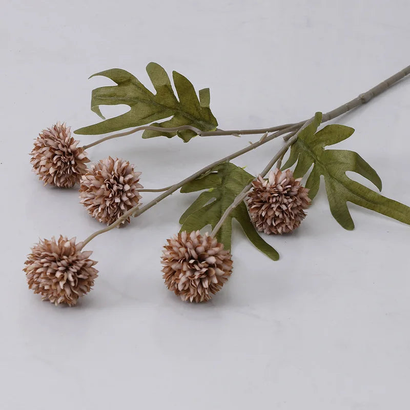 Artificial decorative branch with soft pink pom pom flowers and textured green leaves