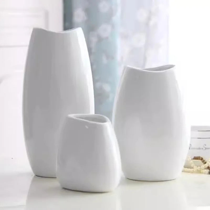 Set of three white ceramic vases in various shapes for elegant home decor