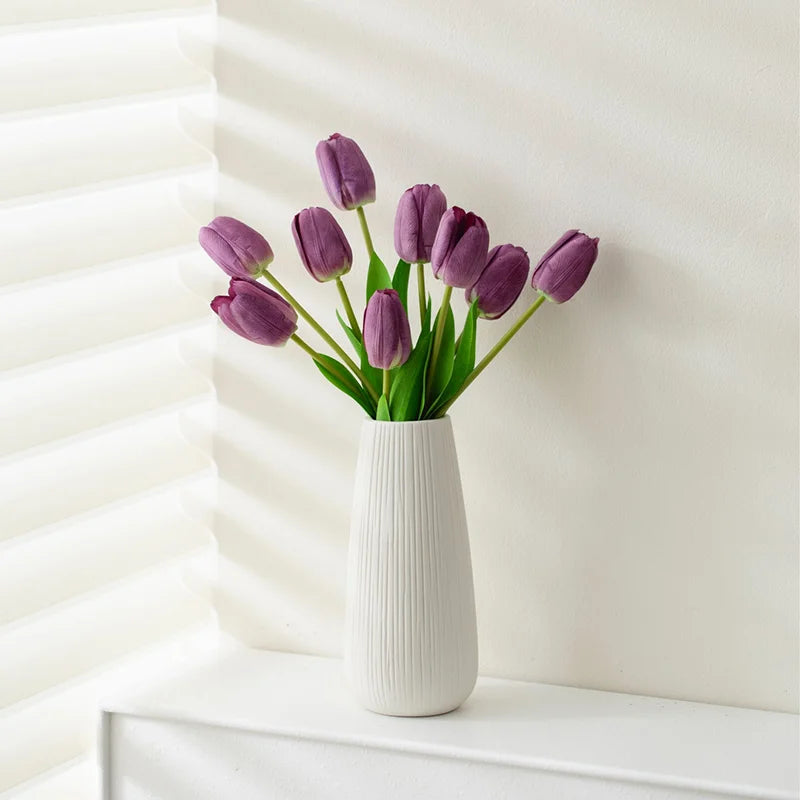 Elegant white ceramic jarrones for home decoration featuring purple tulips in a modern vase