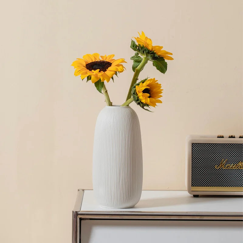 Elegant white ceramic jarrones for home decoration with fresh sunflowers
