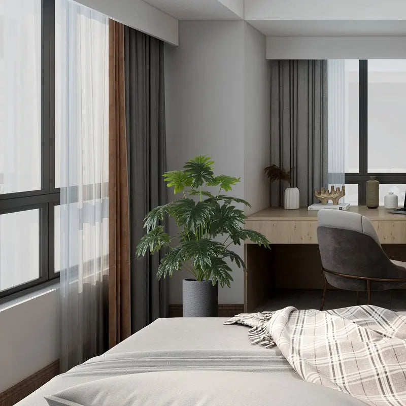 Modern bedroom interior featuring a cozy bed, desk with chair, and indoor plant for a relaxing ambiance