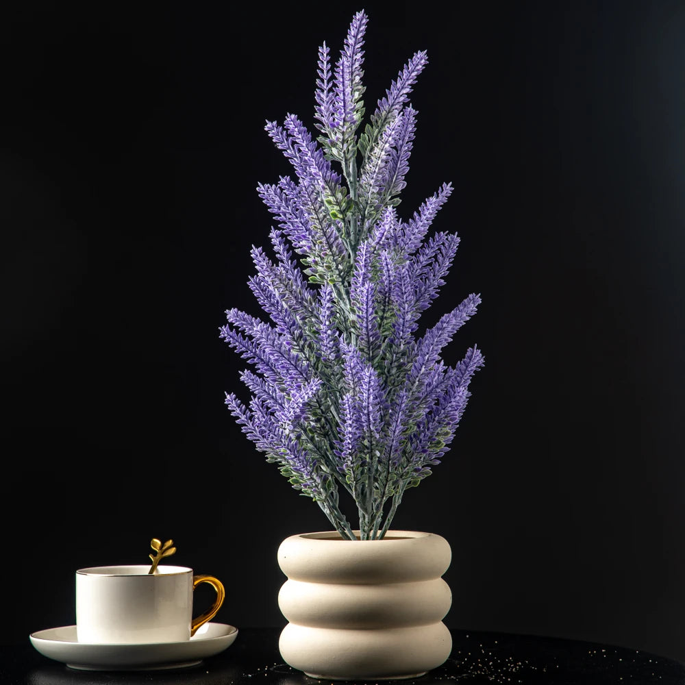 Lavender artificial plant in a modern white pot with a coffee cup beside it