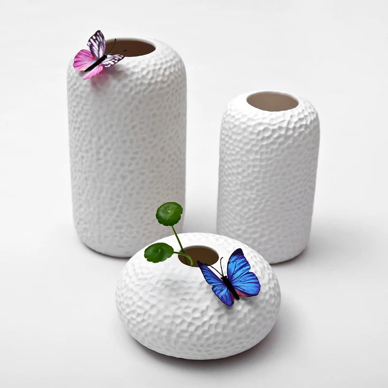 Set of three textured modern ikebana vases in white with colorful butterfly accents