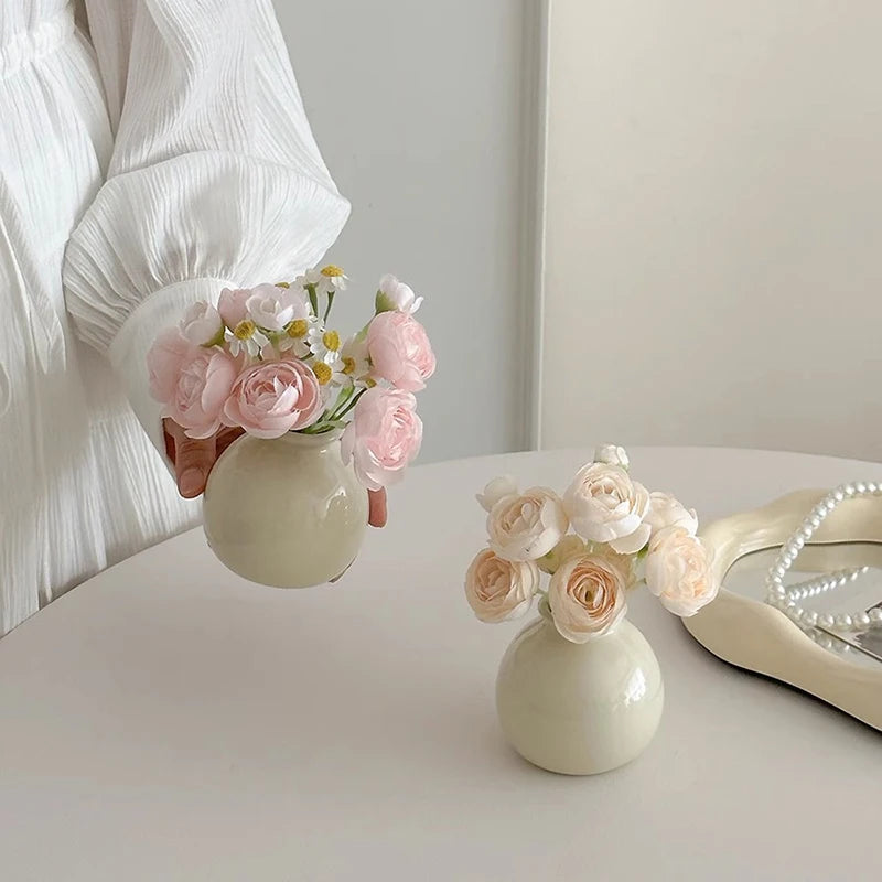 Woman holding a modern mini flower vase with pastel roses and decorative flowers for home decor