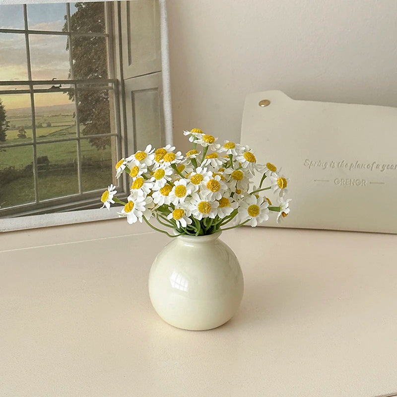 Modern mini flower vase with white and yellow faux flowers on a light background