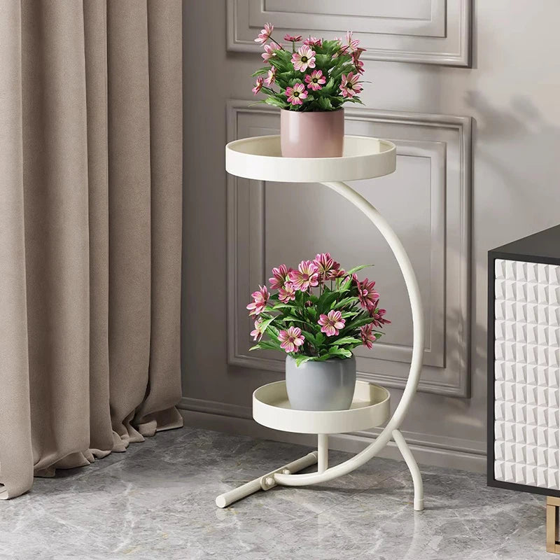 Modern plant stand indoor with two circular shelves and potted flowers in an elegant living room setting