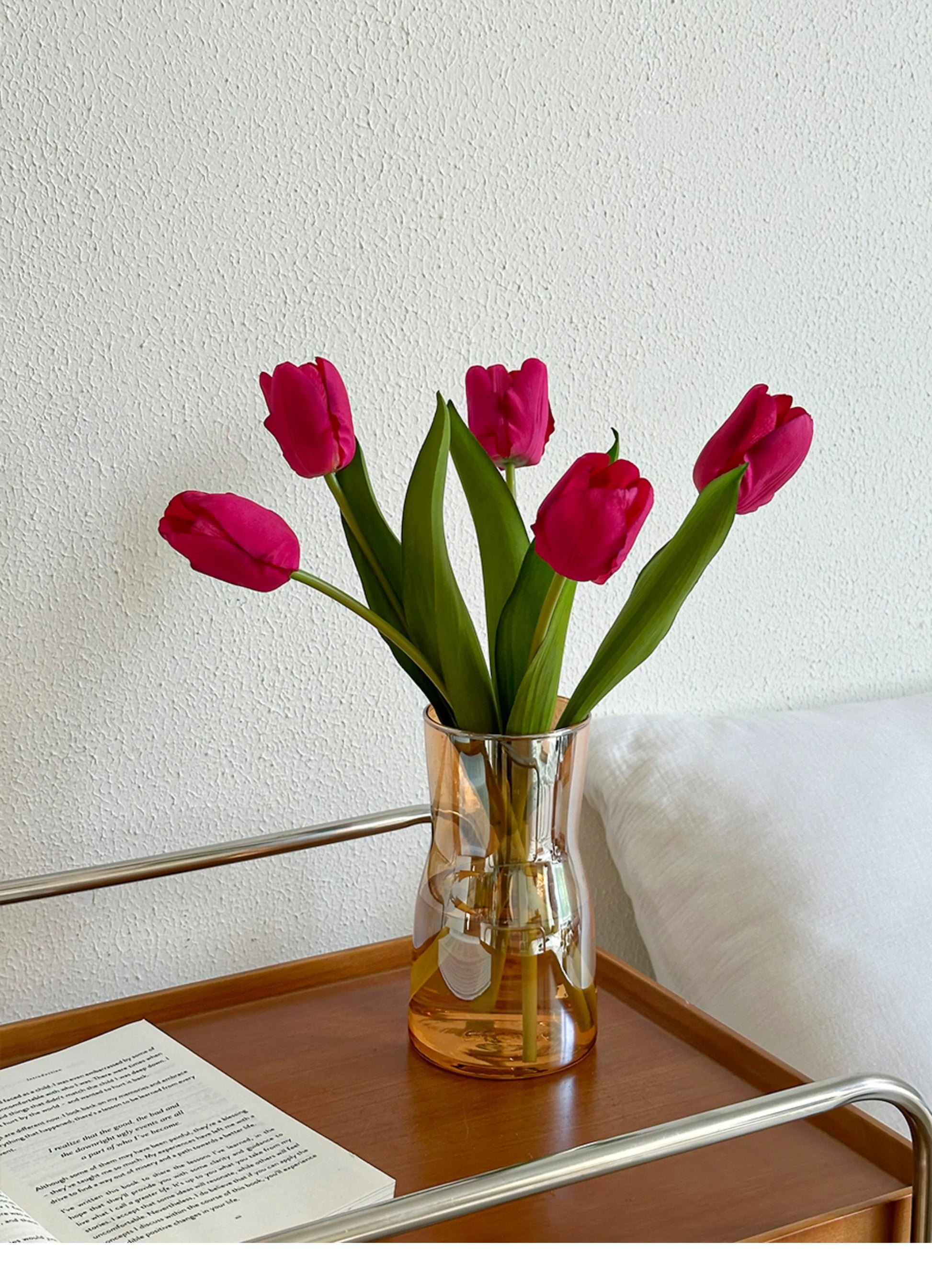 Nordic glass vase decor filled with vibrant pink tulips on a wooden table