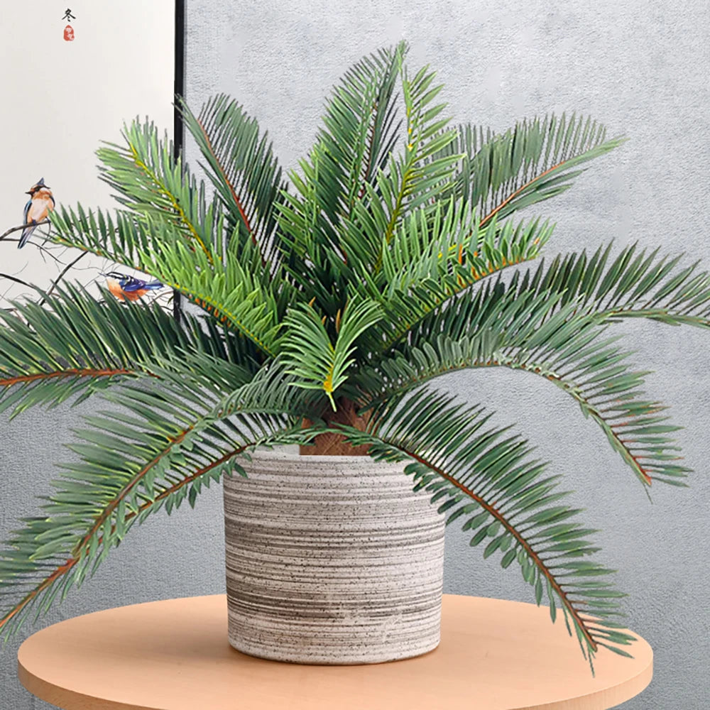 Decorative faux potted palm plant with lush green leaves in a textured gray pot