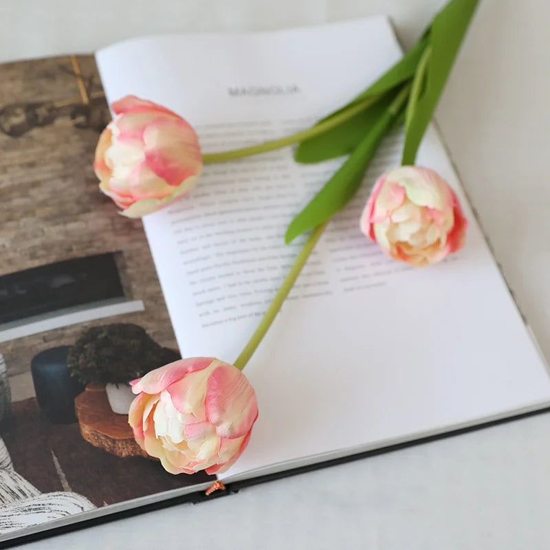 Artificial Magnolia Flowers in Pink on an Open Coffee Table Book for Home Decor