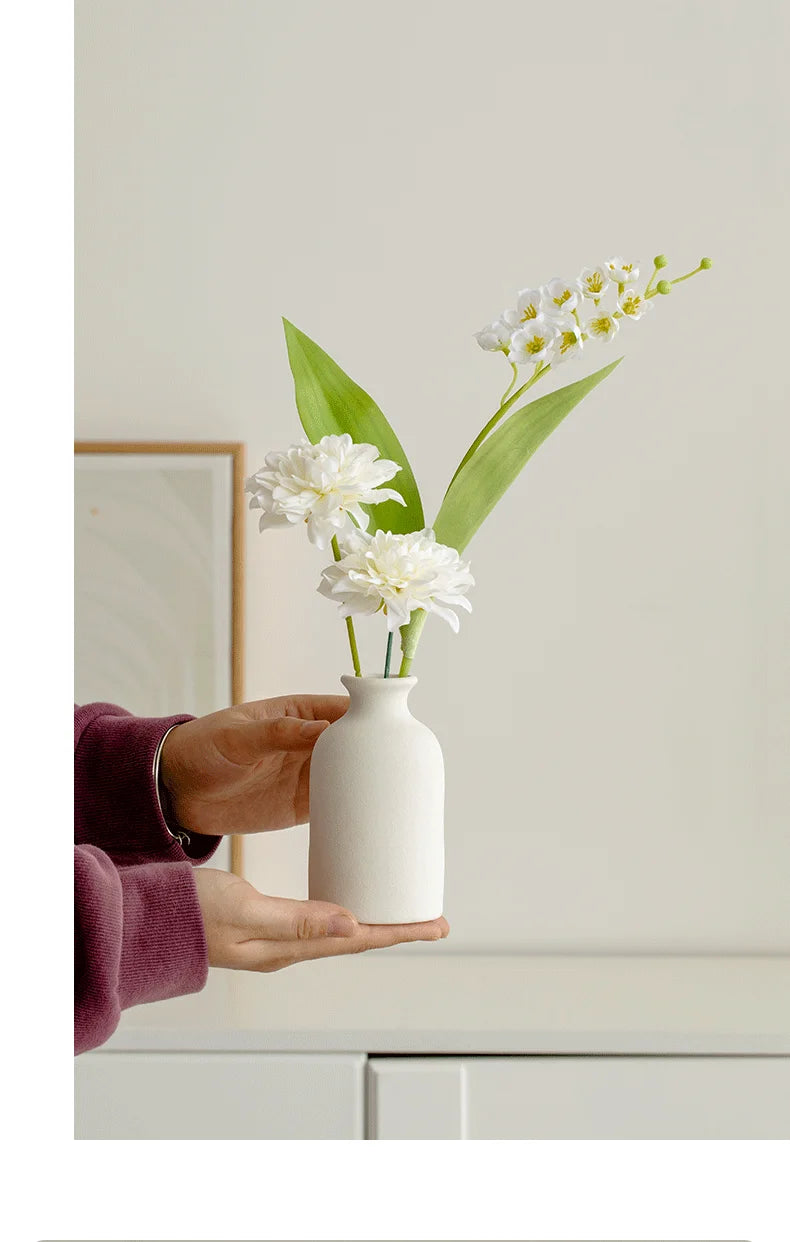 White ceramic vase with artificial flowers held in hands for home decor by Mağazam