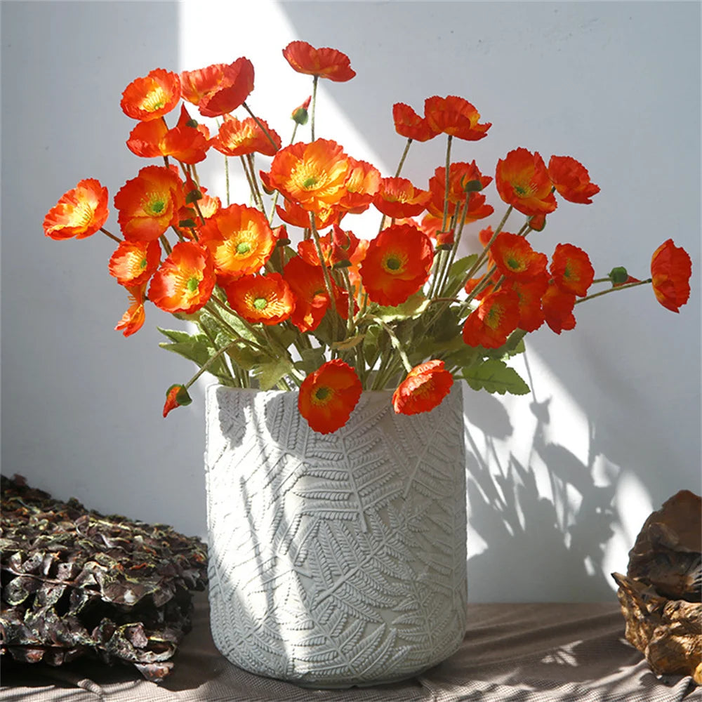 Artificial orange poppy flowers in a textured white planter for home decor