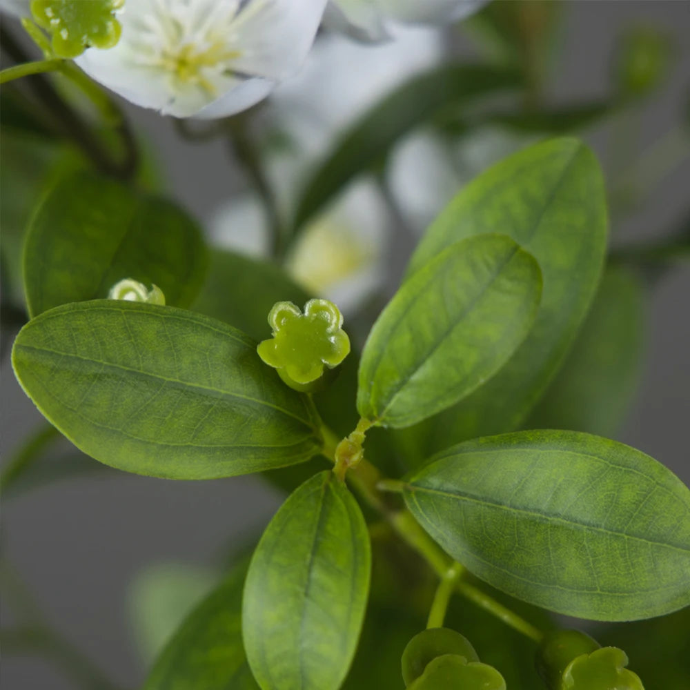Close-up of Mağazam decorative green leaves and white flowers for home decor