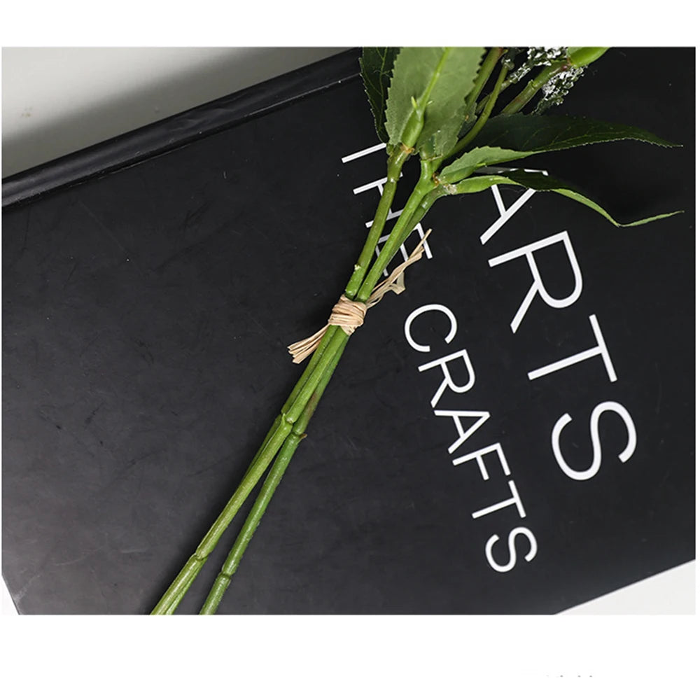 Artificial green foliage bouquet tied with twine on a black arts and crafts book
