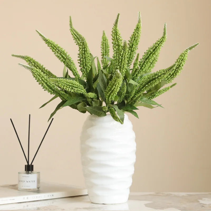 Artificial green plant arrangement in a textured white vase for home decor