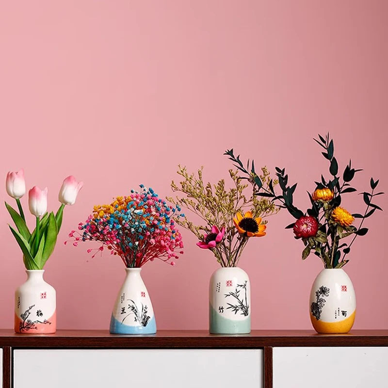 Collection of vintage small flower vases with colorful flowers on a wooden shelf against a pink background